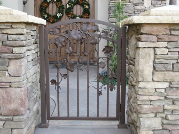 Ornate wrought iron gate between stone pillars